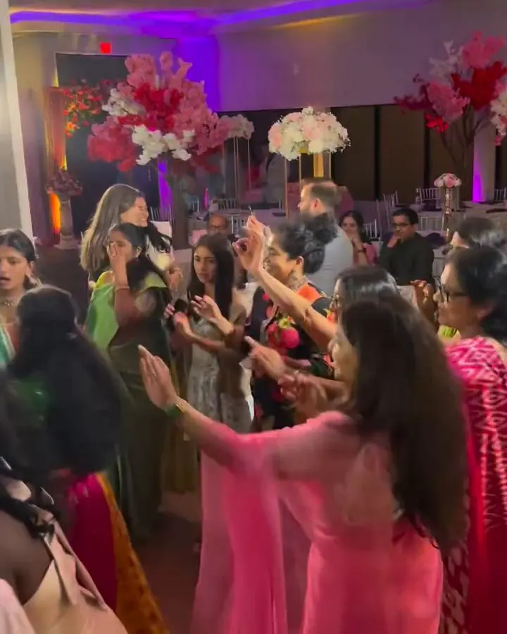Guests celebrating on a dance floor under colorful lights